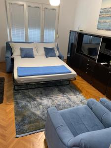 a bedroom with a bed and a couch and a tv at Apartment Blue in Stobreč