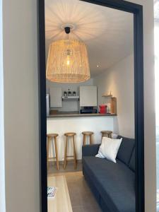 un soggiorno con divano blu e una cucina di Appartement T2 La Ferté Gaucher à 200m du centre a La Ferté-Gaucher