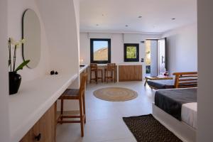 a bedroom with a bed and a living room at Ryolithos Suites in Foinikiá