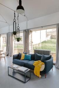 ein Wohnzimmer mit einem blauen Sofa und einem Tisch in der Unterkunft The Cotswold Farm Hideaway in Alderley