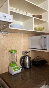 eine Küchentheke mit einem Mixer und einer Mikrowelle in der Unterkunft 07- Acogedor departamento Familiar in Santa Cruz de la Sierra