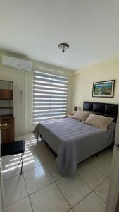ein Schlafzimmer mit einem Bett und einem großen Fenster in der Unterkunft 07- Acogedor departamento Familiar in Santa Cruz de la Sierra