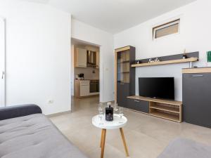 ein Wohnzimmer mit einem Sofa, einem TV und einem Tisch in der Unterkunft Amoroso apartment 200m from sea in Poreč