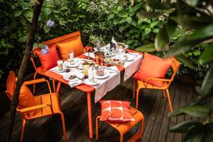 a table with orange chairs and food on a deck at Buxbaum Beletage Design & Boutique Hotel in Vienna