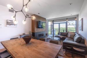 ein Wohnzimmer mit einem Tisch und einem Sofa in der Unterkunft Horizon 1-203 / Warm and cozy condo with a view! in Mont-Tremblant