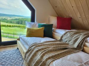 2 Betten in einem Zimmer mit einem großen Fenster in der Unterkunft Osada Gilówka - domki Rabka Zdrój in Rabka-Zdrój