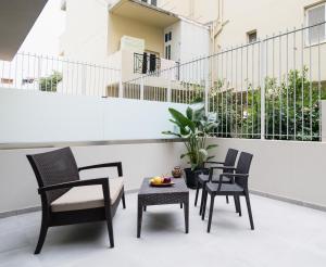a patio with chairs and a table on a balcony at Noema Urban Living in Heraklio