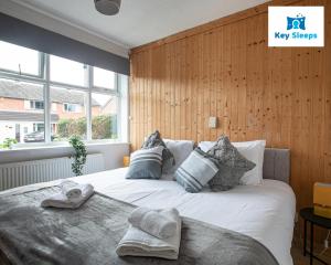 1 dormitorio con 1 cama con sábanas y almohadas blancas en Keysleeps - Stunning Bungalow & Contractors & Leisure & Private Parking & Garden - Pelsall en Pelsall