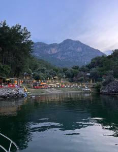 a river with a group of people on the shore at Köyceğiz Sultaniye Camping in Mugla