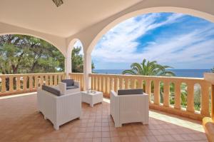 Un balcón con sillas y vistas al océano. en Villa Opunzie Torre Vado, en Torre Vado