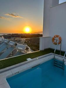 a swimming pool on top of a building with the sunset at Sunset view * Swimming pool* A/C in Tarifa