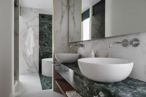 un bagno con ampia vasca bianca e lavandino di Parioli Hotel Rimini a Rimini