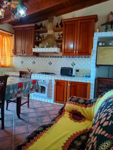 a kitchen with wooden cabinets and a table with a blanket at casa Selene in Lampedusa