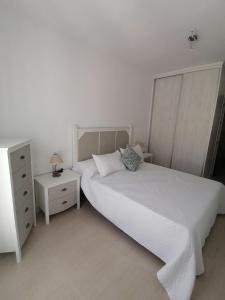 una camera bianca con letto e comodino di Vandelvira a Baeza