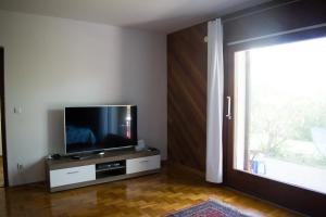 Il comprend un salon doté d'une télévision à écran plat et d'une fenêtre. dans l'établissement Apartma Marin, à Portorož