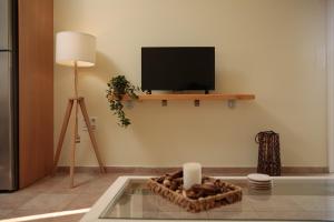 納克索喬拉的住宿－Green Loft room in Naxos Chora，客厅配有平面电视和桌子。