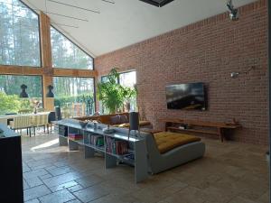 a living room with a couch and a brick wall at LALA Kłączno małe SPA in Kłaczno