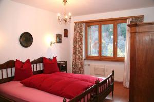 クロスタースにあるMonami Apartments Klosters, Apt. Solavers No 1のベッドルーム1室(赤い枕の大型ベッド1台付)