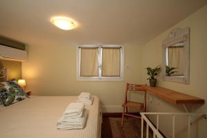 a bedroom with two beds and a window and towels at Green Loft room in Naxos Chora in Naxos Chora