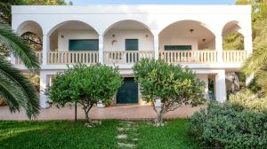 una gran casa blanca con árboles en el patio en Villa Opunzie Torre Vado, en Torre Vado