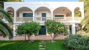 una grande casa bianca con alberi nel cortile di Villa Opunzie Torre Vado a Torre Vado