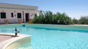 una copa de vino junto a la piscina en Villa Opunzie Torre Vado, en Torre Vado