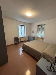 um quarto com uma cama, uma cadeira e 2 janelas em Cà du Miliu em Sesta Godano