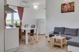a living room with a couch and a table at Apartment Miruna s bazenom i jakuzijem in Donje Raštane