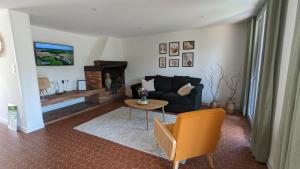 a living room with a couch and a table at Maison au bord de la rivière Aveyron - Bruniquel in Bruniquel