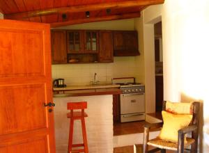 a kitchen with wooden cabinets and a stove top oven at CABAÑAS AGUA DEL MEDIO in Las Heras