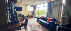 ein Wohnzimmer mit einem blauen Sofa und einem Fenster in der Unterkunft Revive Guesthouse in Darling