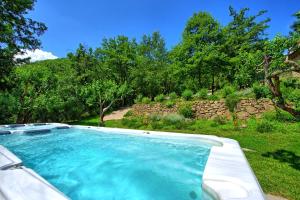 a large swimming pool in a yard with trees at Villa Mulino by PosarelliVillas in Poggioni