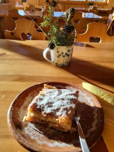 a piece of cake on a plate on a table at Valvasorjev dom pod Stolom in Žirovnica