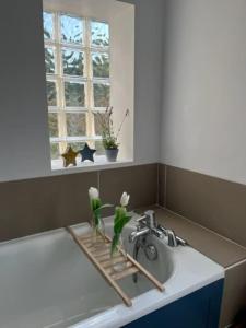 um lavatório de cozinha com um vaso de flores em Character Snowshill Cottage - 2 Glebe Cottage’s em Snowshill