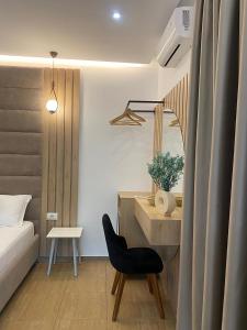 a bedroom with a desk and a chair and a mirror at Kuburi Hotel in Ksamil