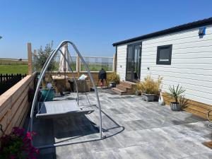 a swing set on a patio next to a building at Luxus Chalet Meeresweitblick in Westerland
