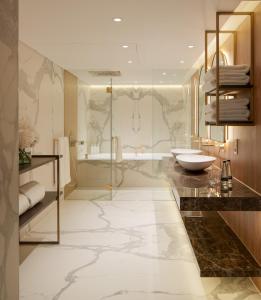 een badkamer met een bad, een wastafel en een douche bij St Martins Lane London in Londen