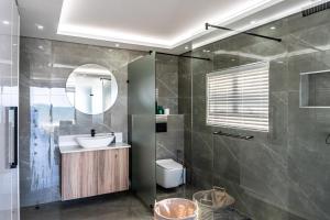 uma casa de banho com um lavatório, um WC e um espelho. em Luxurious 3 bedroom beach front apartment em Ballito