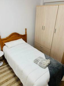 a bedroom with a white bed and a cabinet at Apartamento Ruiz Zorrilla in Santander
