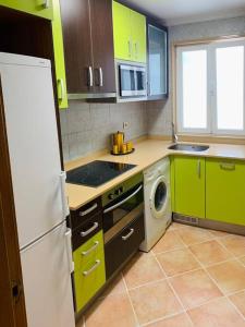 a kitchen with green cabinets and a white refrigerator at Apartamento Ruiz Zorrilla in Santander