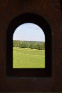 een uitzicht op een grasveld door een raam bij Le Chalet du Gégé in Bouillon