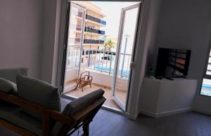 ein Wohnzimmer mit einem Sofa und einem großen Fenster in der Unterkunft Amplio piso con terraza a 50 m de playa Miramar in Miramar
