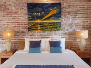 a bedroom with a bed and a painting on the wall at Spaces Bali Unique Boutique Hotel in Munggu