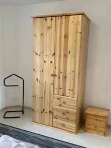 a wooden cabinet next to a wall with a desk at Ferienwohnung Weber in Sehmatal +10 photos