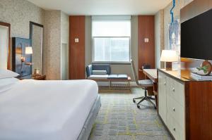 een hotelkamer met een bed, een bureau en een stoel bij Renaissance Atlanta Midtown Hotel in Atlanta