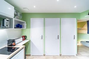 dois armários brancos numa cozinha com paredes verdes em Sleep and go -cosy 9 pers-Oullins em Oullins