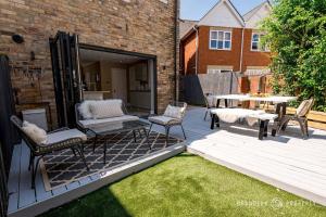 a patio with a table and chairs and a table at Luxury 4-Bed with Garden, WiFi & Parking - Pottery Place in Poole
