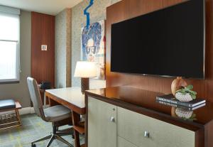 a hotel room with a desk and a flat screen tv at Renaissance Atlanta Midtown Hotel in Atlanta