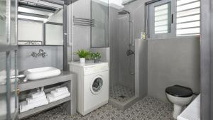 a bathroom with a washing machine and a sink at Monastiraki Factory Living- Unspoiled Athens Apartments in Athens