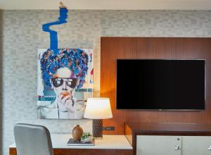 a living room with a tv and a table with a lamp at Renaissance Atlanta Midtown Hotel in Atlanta